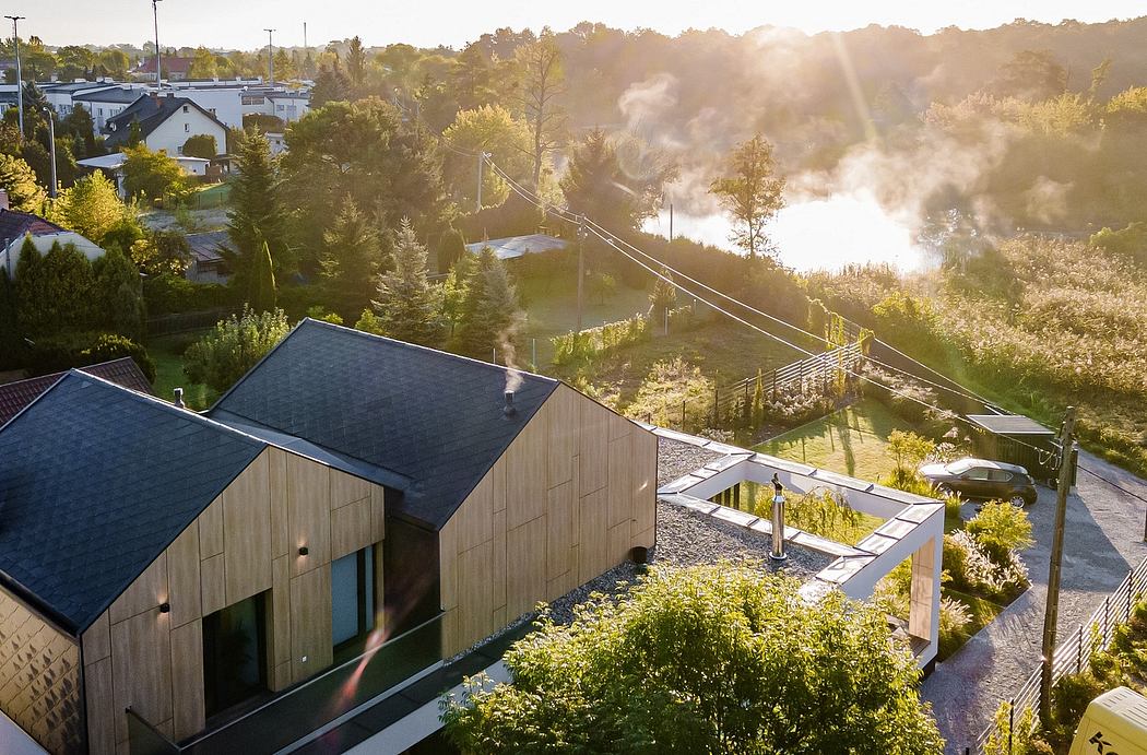 Modern wooden houses with green roofs nestled among lush vegetation and scenic landscape.