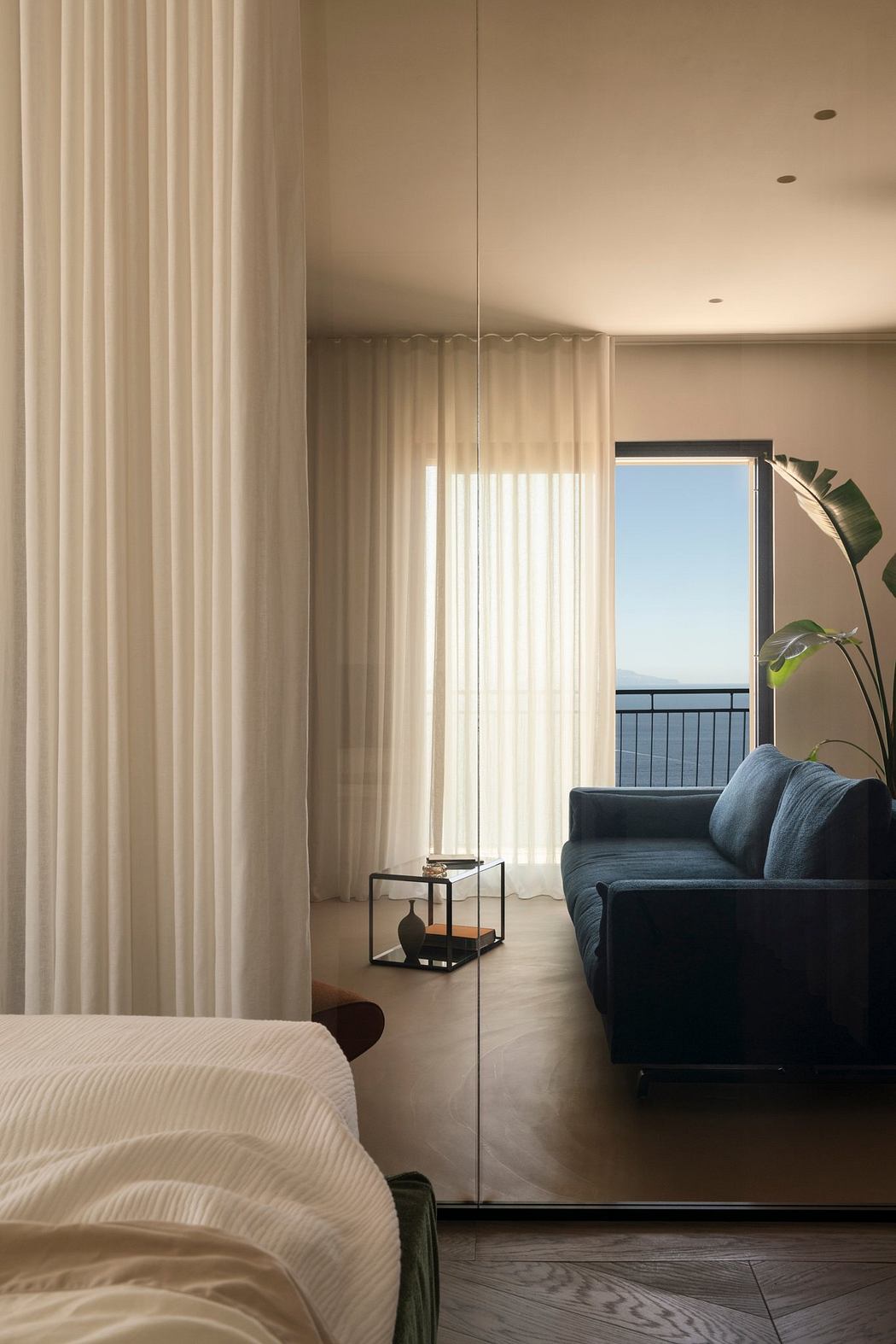 Soft, neutral-toned curtains frame a modern living space with a blue sofa and minimalist decor.