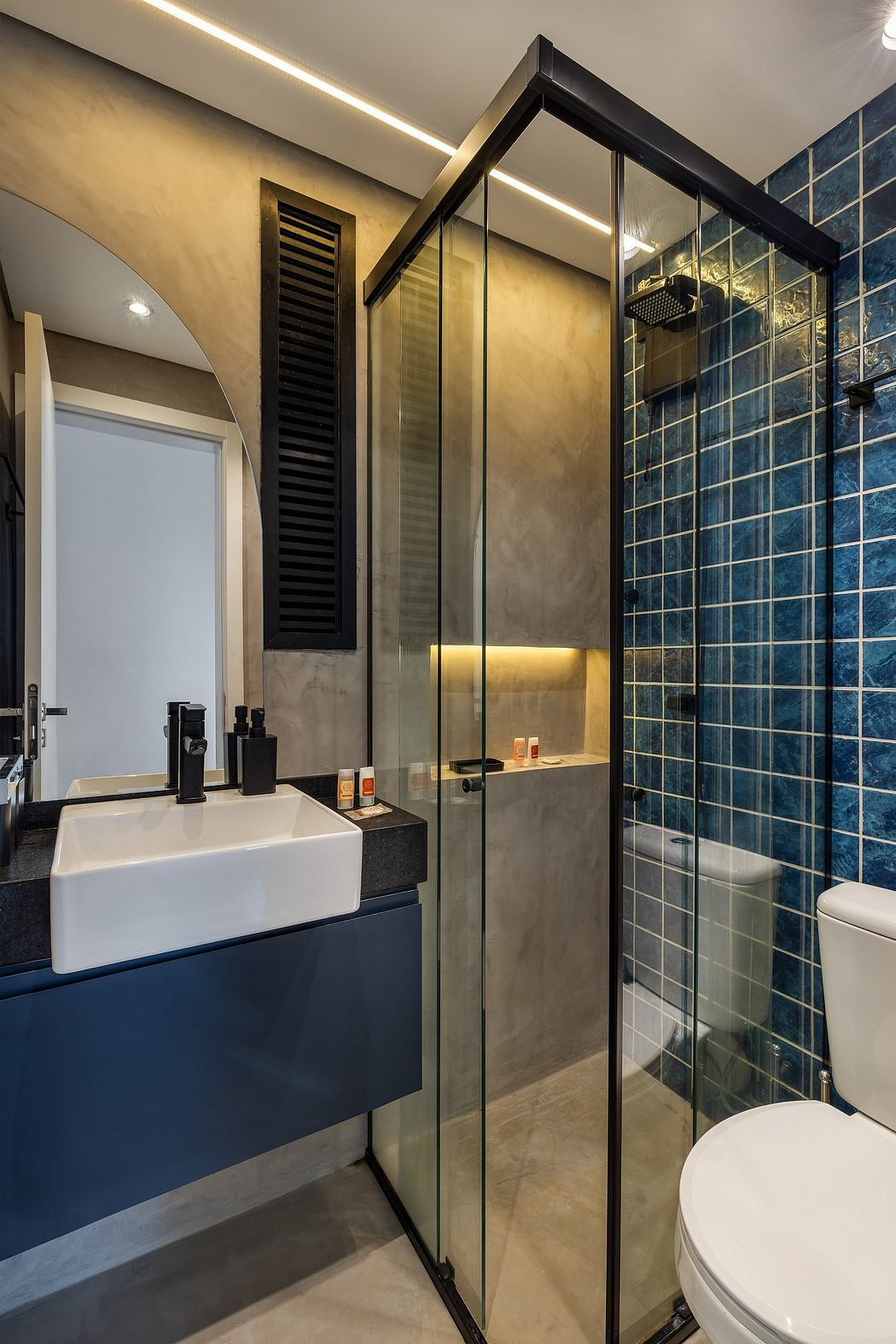 Sleek modern bathroom with glass shower, floating vanity, and textured wall tiles.