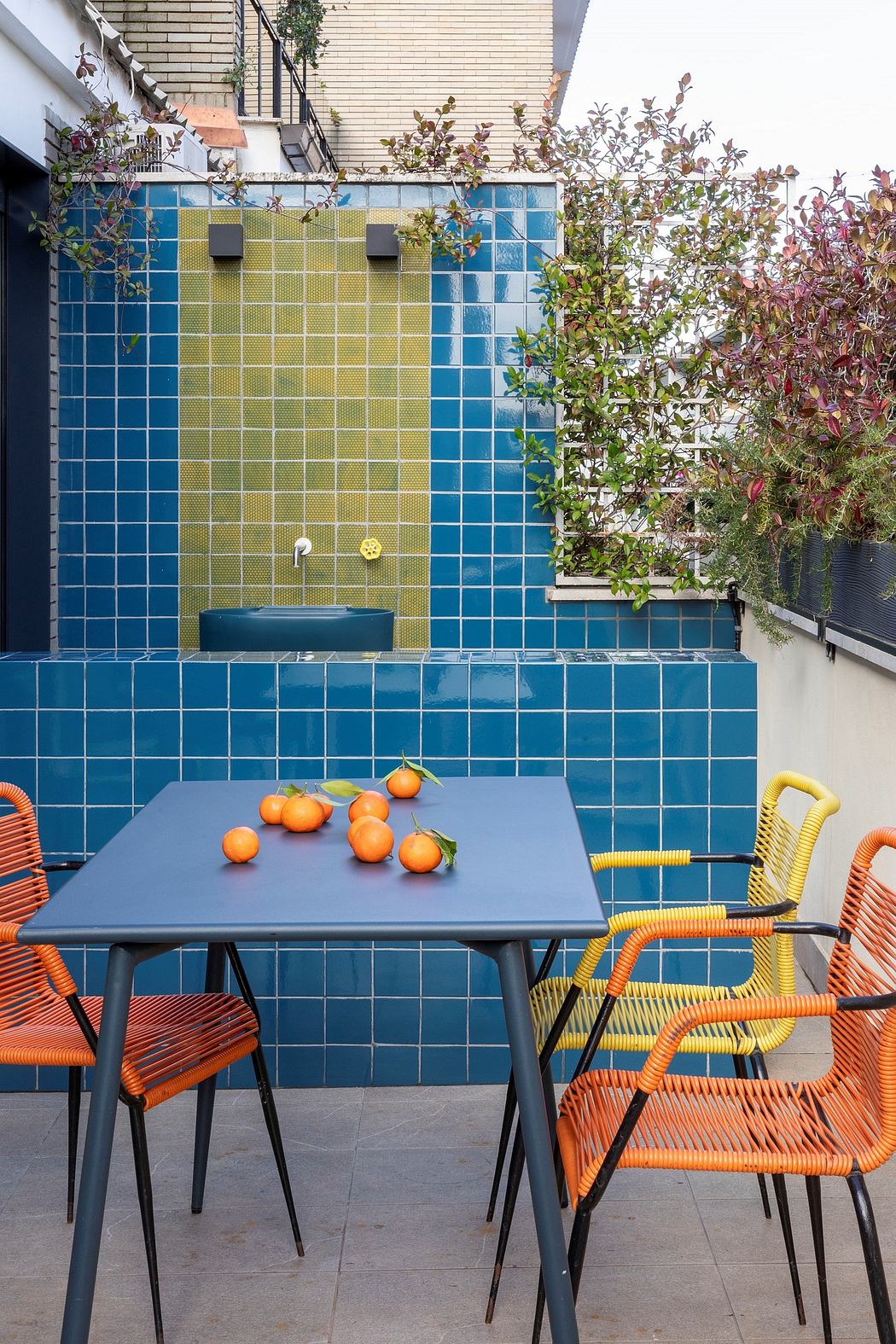 Vibrant outdoor dining space surrounded by colorful tiled walls and lush foliage.