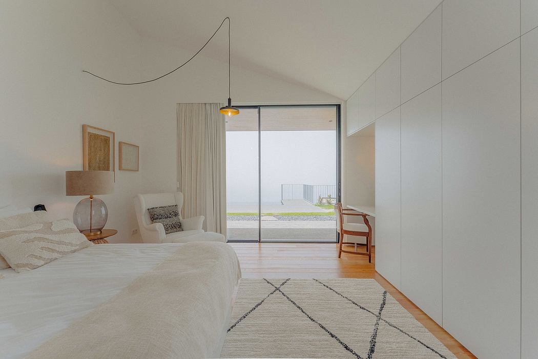 Minimalist bedroom design with large window, wood floors, and geometric rug.