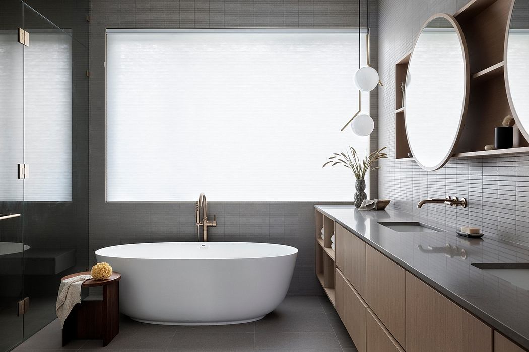 Minimalist bathroom design with freestanding tub, vanity, and round mirrors against natural light.