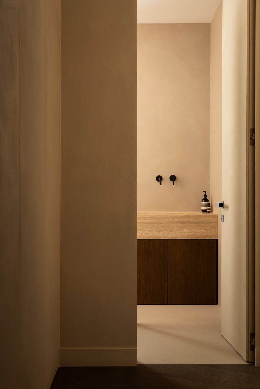 A minimalist bathroom with a wooden vanity, black fixtures, and clean lines.