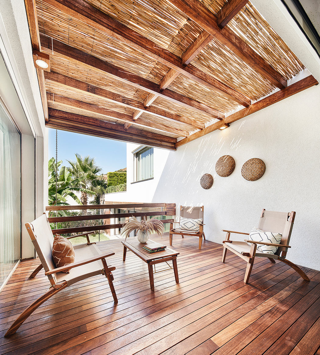 Wooden thatched ceiling and deck with seating area and tropical vegetation view.