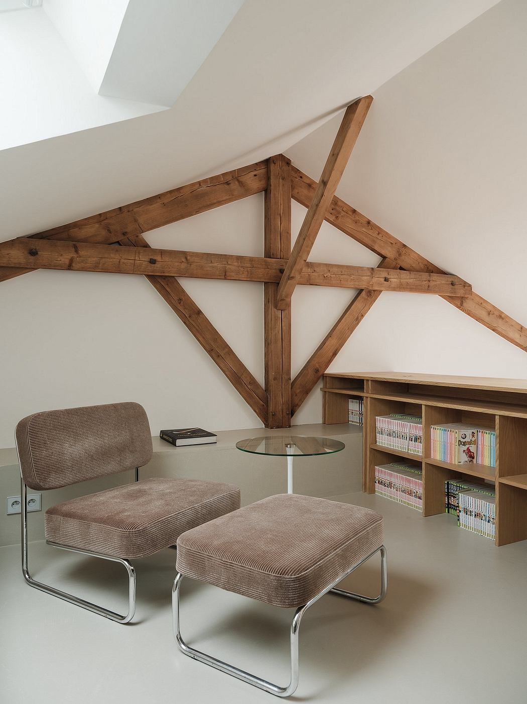 Cozy reading nook with wooden beams, cushioned chairs, and built-in bookshelves.