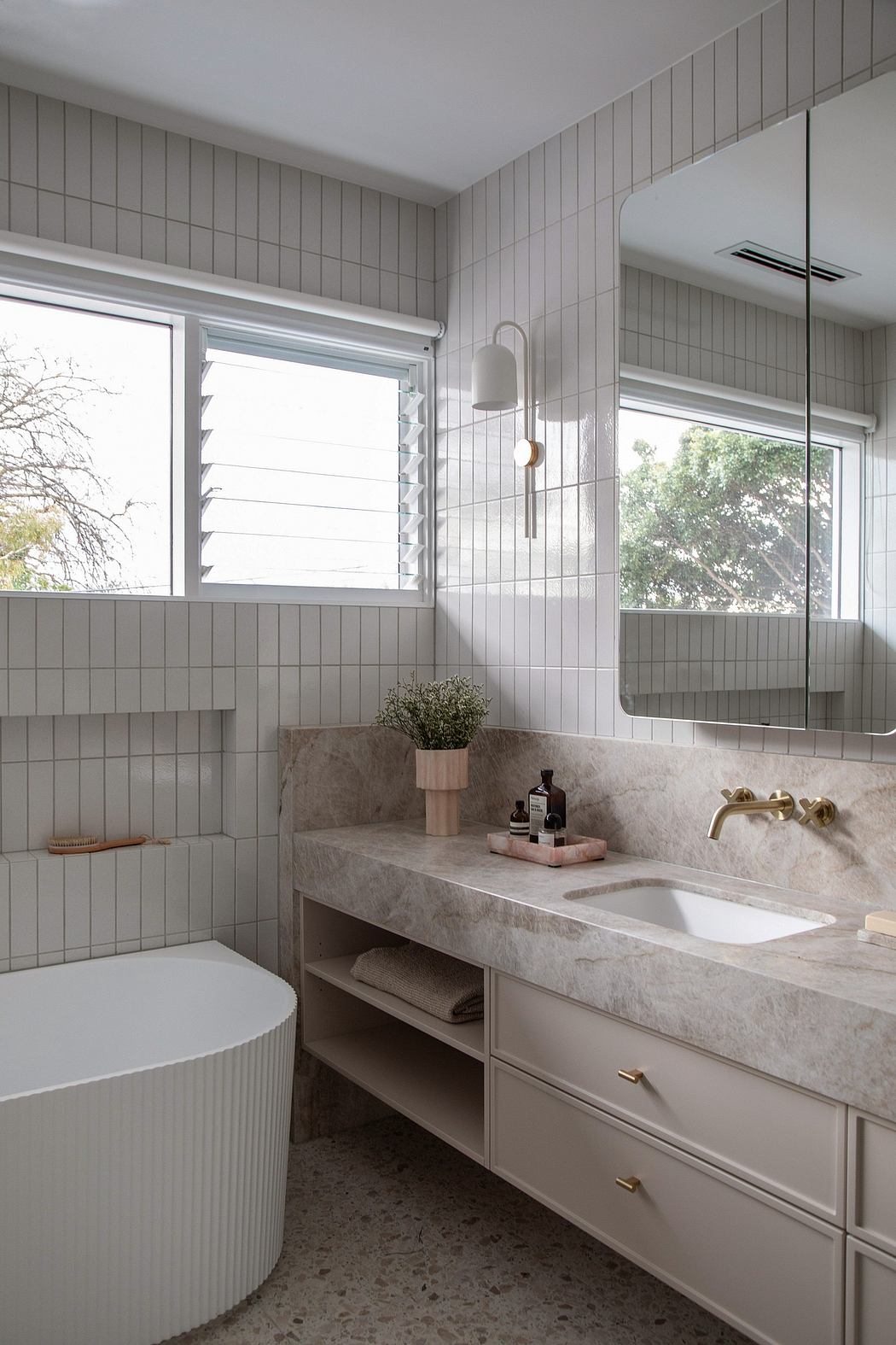 A modern bathroom with tiled walls, a stone vanity, and minimalist fixtures.