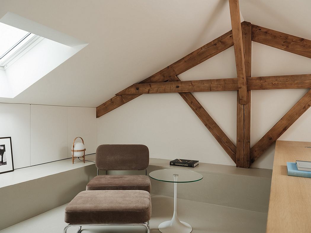 Cozy attic nook with exposed wooden beams and minimal, modern furnishings.