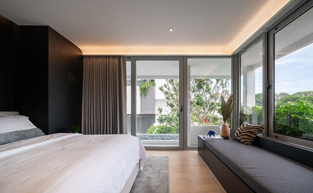 A contemporary bedroom with sleek black cabinetry, large windows, and lush greenery views.