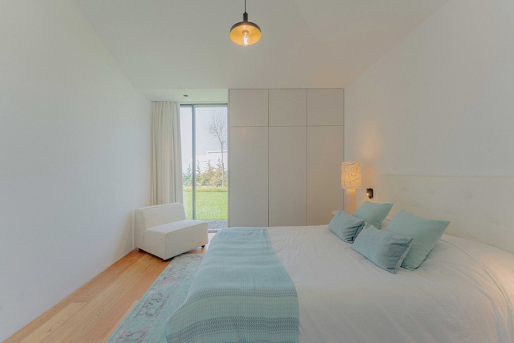 Elegant bedroom with minimalist design, floor-to-ceiling cabinets, and a tranquil view outside.
