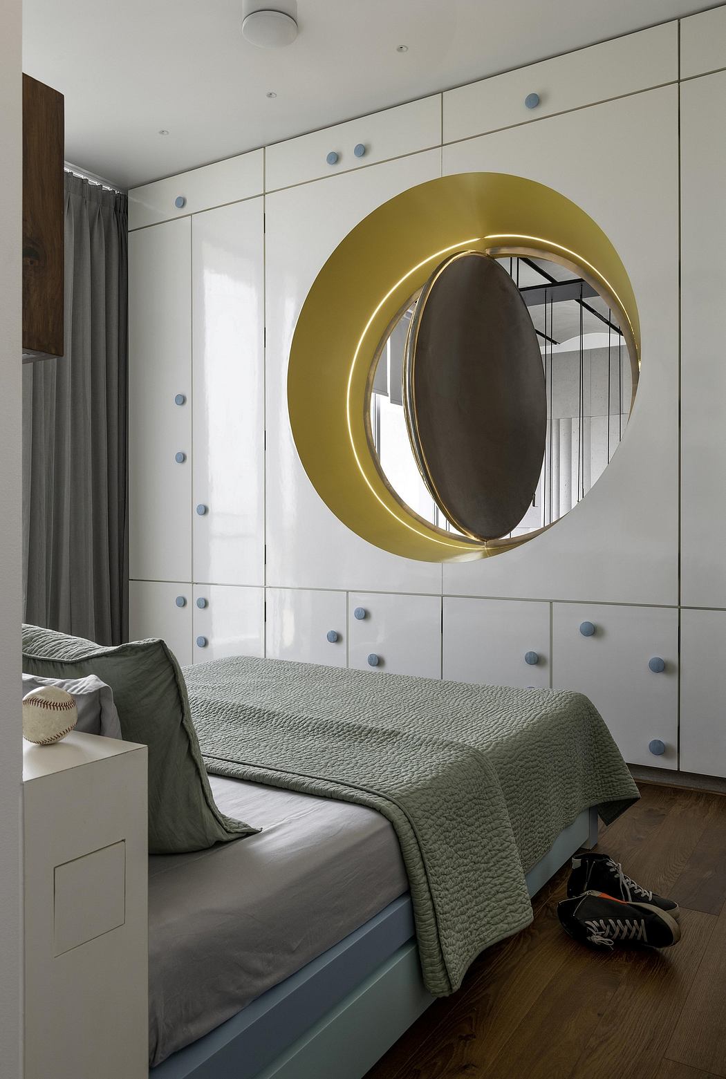 Stylish modern bedroom with circular gold-framed mirror and patterned wall panels.
