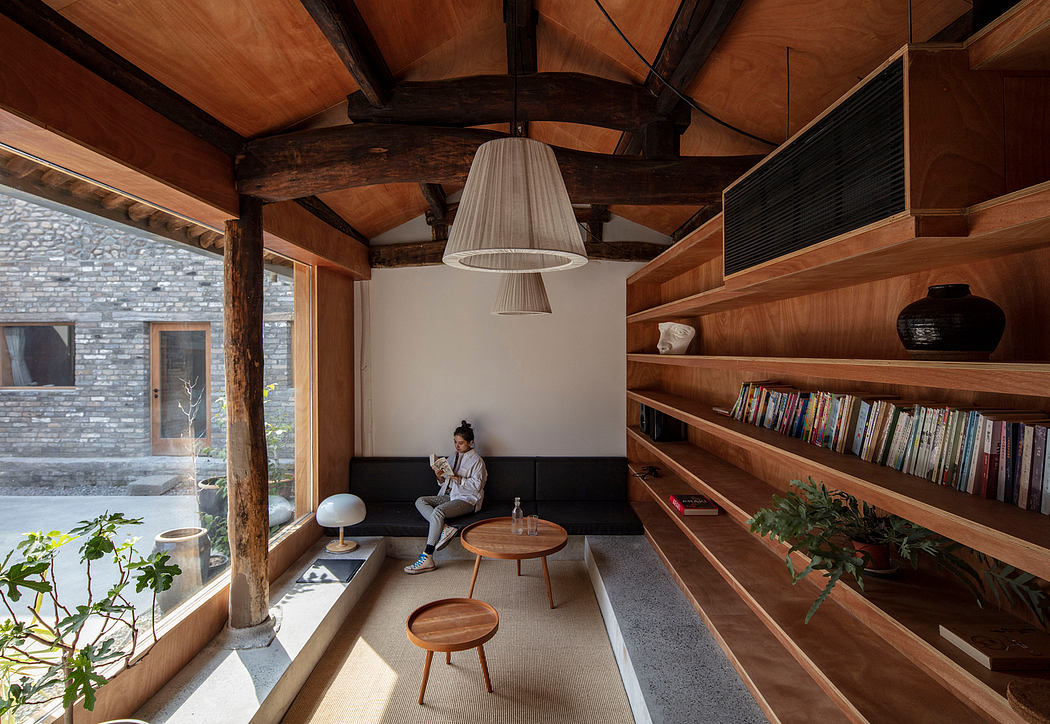 A cozy, rustic living space with wooden beams, built-in shelves, and natural lighting.