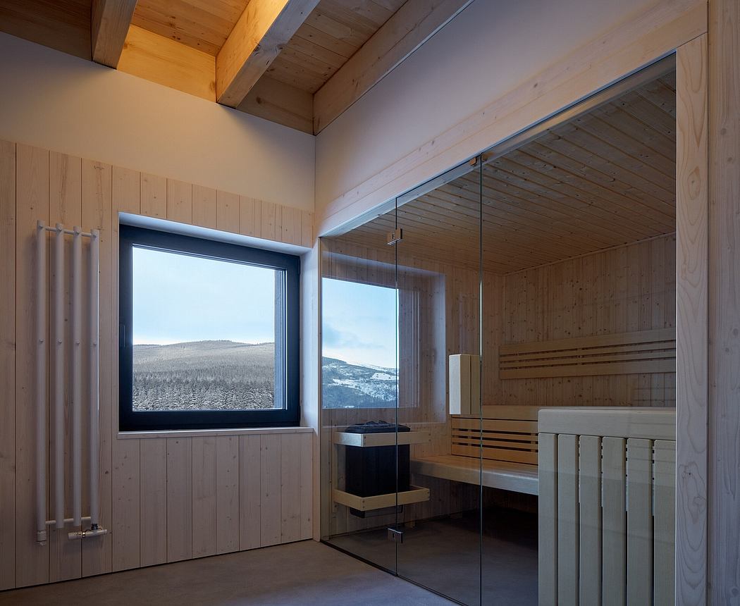 Spacious sauna room with wooden walls, large windows, and modern glass enclosure.