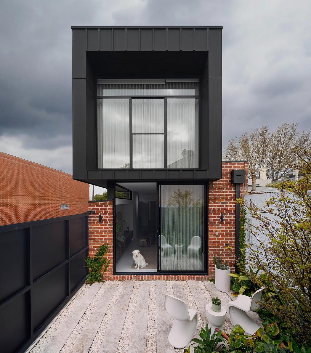 Sleek, modern architectural design with black exterior, large windows, and dog visible.