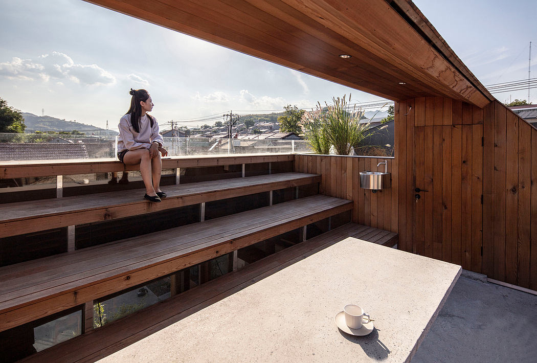 A wooden deck overlooking a city, with steps and a table holding a cup of coffee.