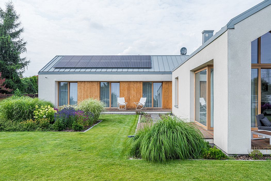 Sleek modern home with solar panels, wooden accents, and lush landscaping.