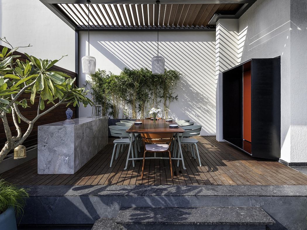 Sleek, minimalist outdoor dining area with concrete, wood, and greenery accents.