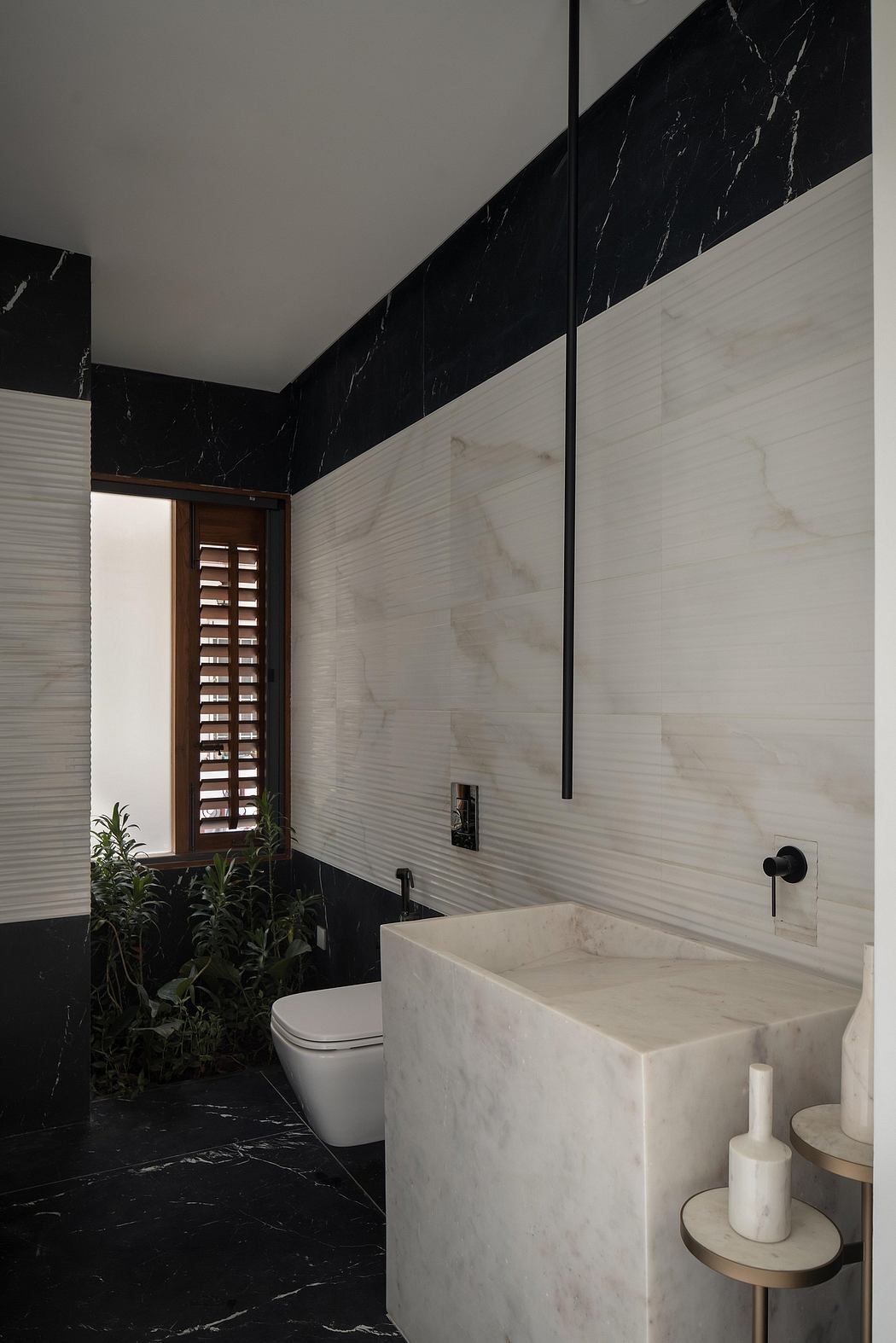 Elegant bathroom design featuring contrasting black and white marble walls, sleek vanity.