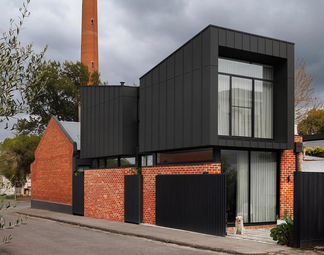 Modern architectural design with contrasting brick and black cladding, large windows.
