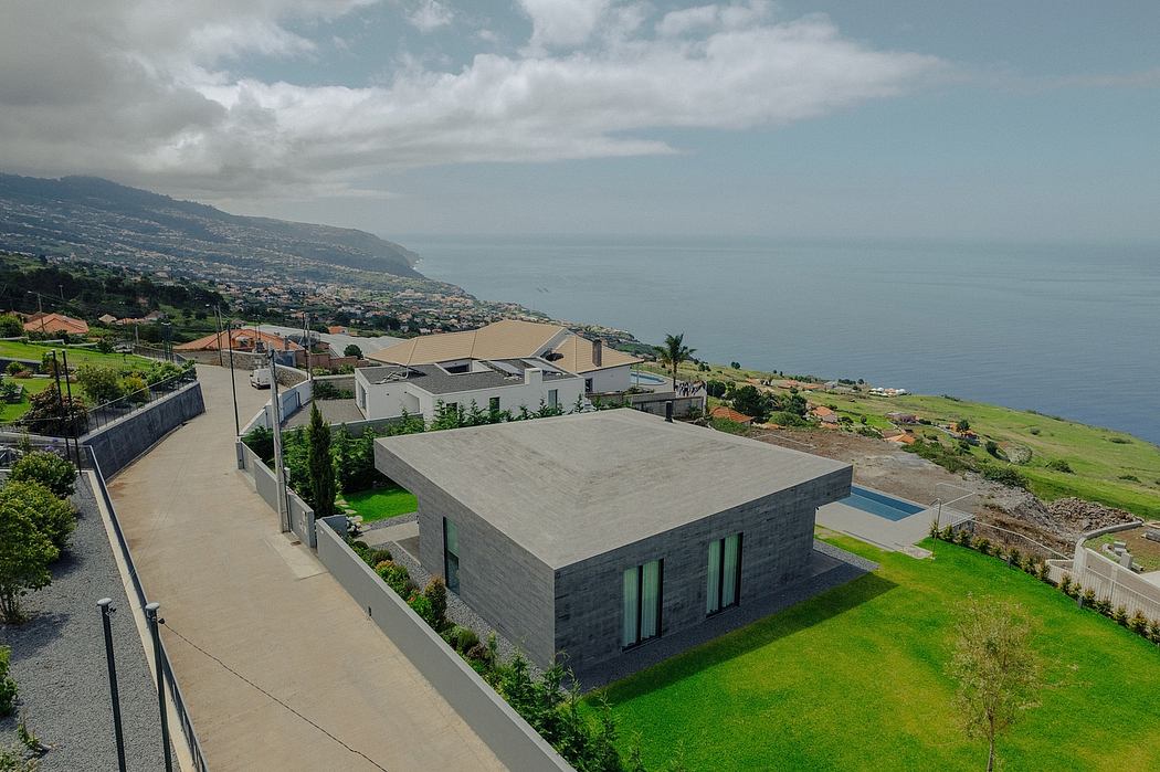 Modern concrete and glass buildings along the coast with lush green landscaping.