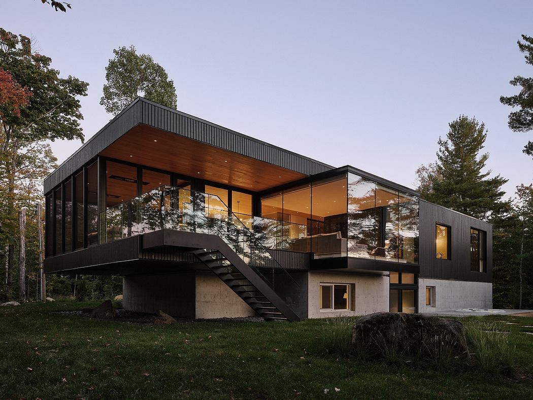 Modern, sleek glass-and-concrete house with a dramatic roofline and cantilevered balcony.