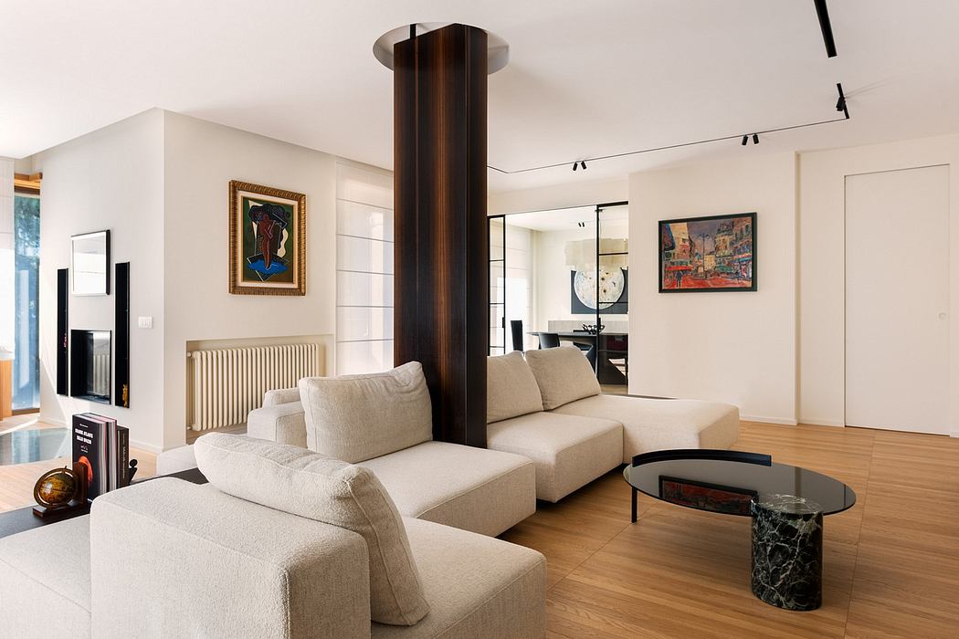 Warm, modern living room with wooden column, artworks, and sleek furniture.