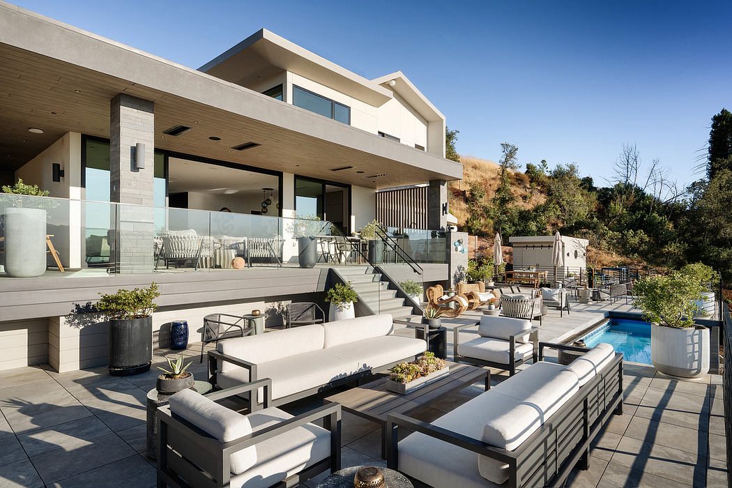 Spacious, modern outdoor living area with pool, seating, and multilevel home design.