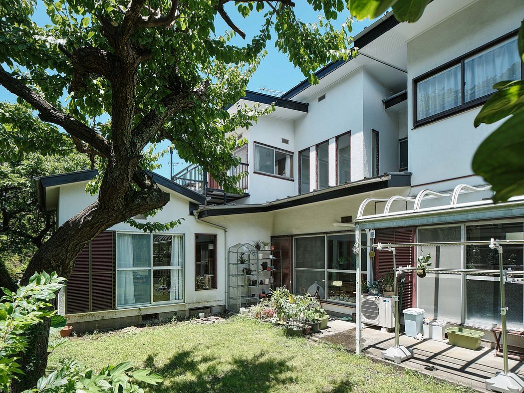 Modern home design with large windows, balconies, and greenery surrounding the exterior.