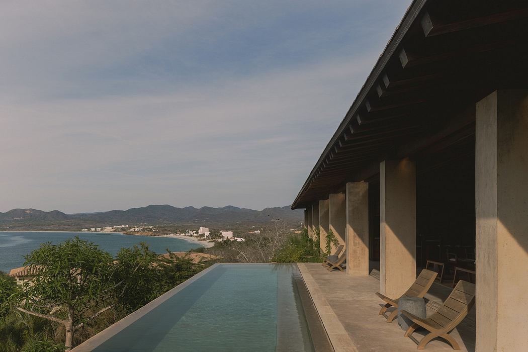 Modern tropical residence with infinity pool overlooking the ocean and mountains.