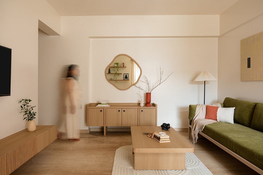 Warm, minimalist living room with wooden furniture, circular mirror, and blurred figure.