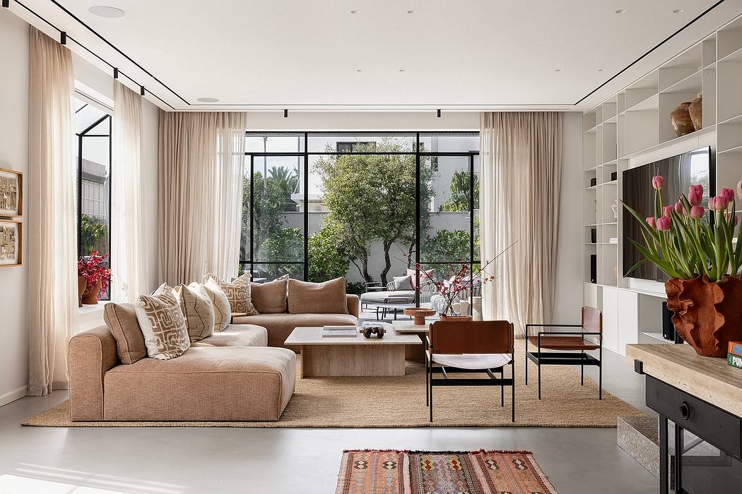 Spacious living room with large windows, neutral color palette, and stylish furnishings.