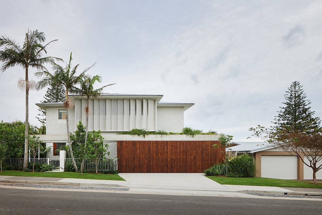 Modern two-story residence with clean lines, wood and stone facade, lush landscaping.