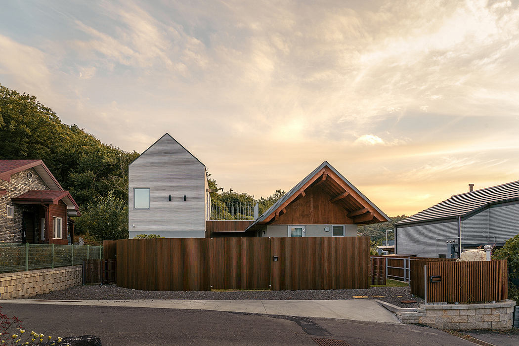 Modern architectural designs featuring wooden and stone structures with varying roof shapes and angles against a cloudy sunset sky.