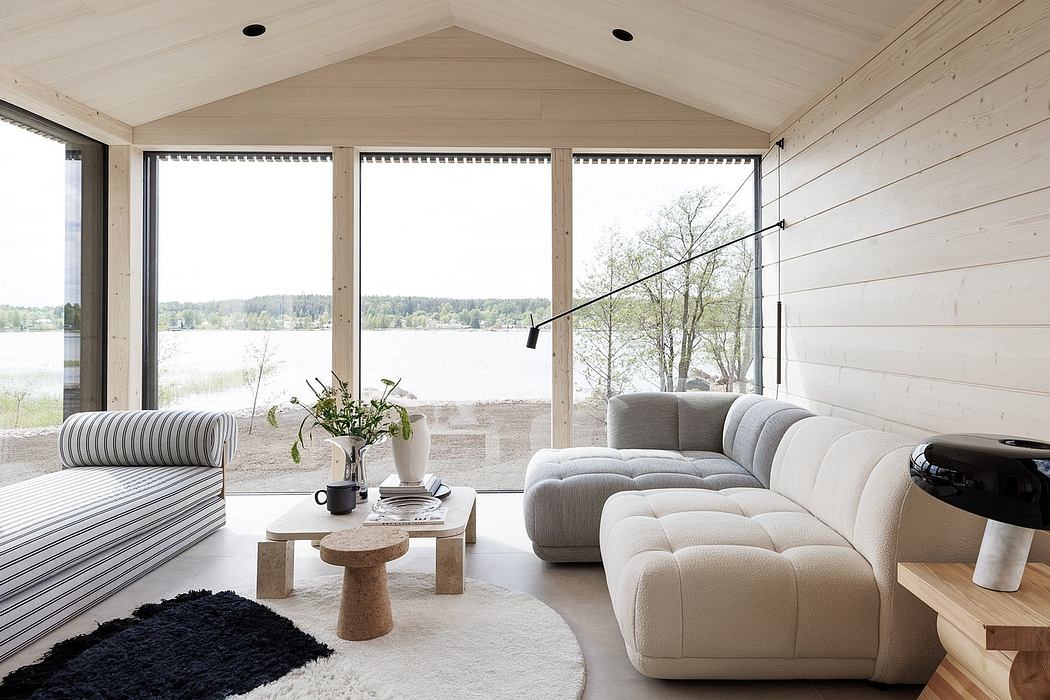 Minimalist cabin design with floor-to-ceiling windows showcasing serene lake view.