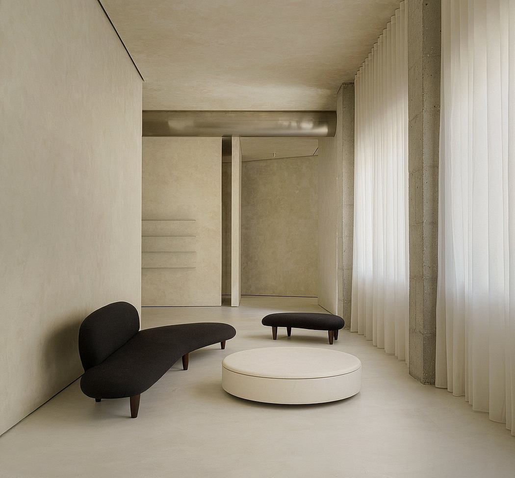 Minimalist architectural interior with curved concrete walls, curtains, and geometric furniture.