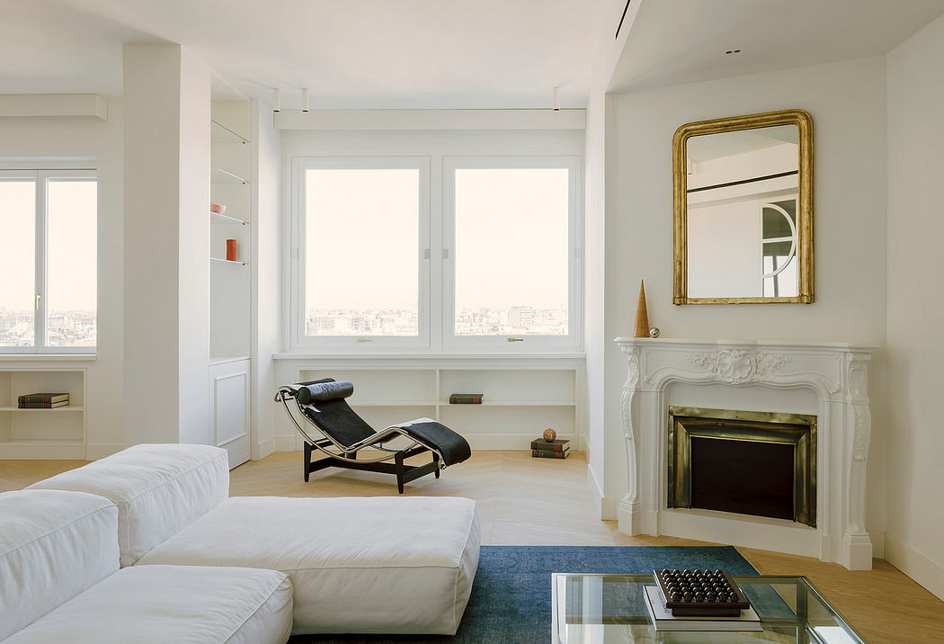 Spacious, modern living room with tall windows, ornate fireplace, and minimalist furnishings.