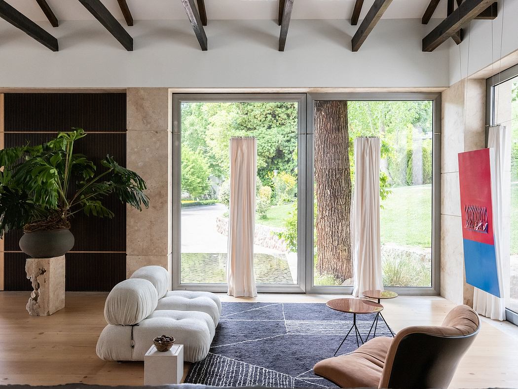 Spacious living room with large windows, wooden beams, and contemporary furniture.