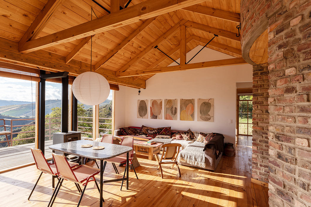 Spacious open-plan interior with exposed wooden beams, brick walls, and cozy seating.