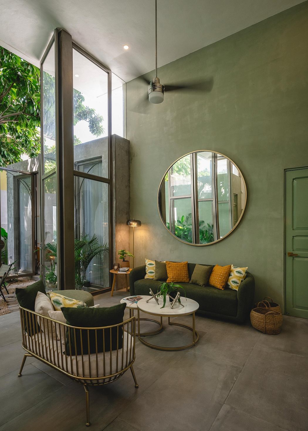 Lush indoor-outdoor space with large windows, plush furniture, and tropical greenery.