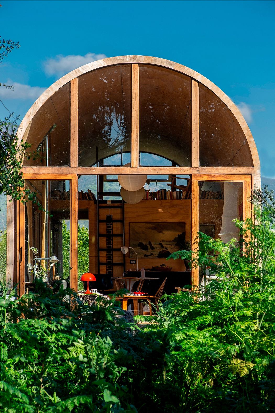 Wooden dome structure with arched windows and shelves filled with various items.