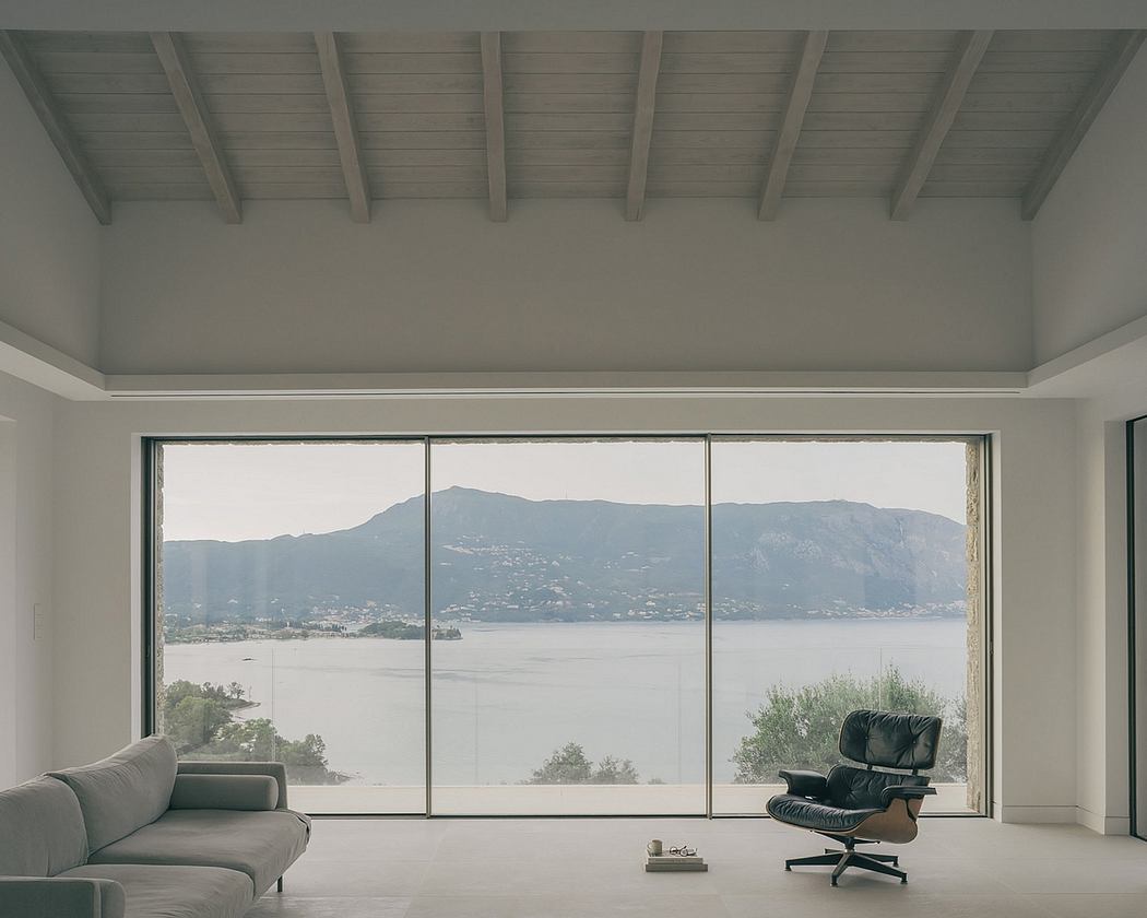 An airy, modern interior with panoramic lake and mountain views through expansive windows.