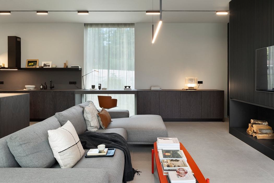 A modern, minimalist living room with sleek dark wood furniture and recessed lighting.