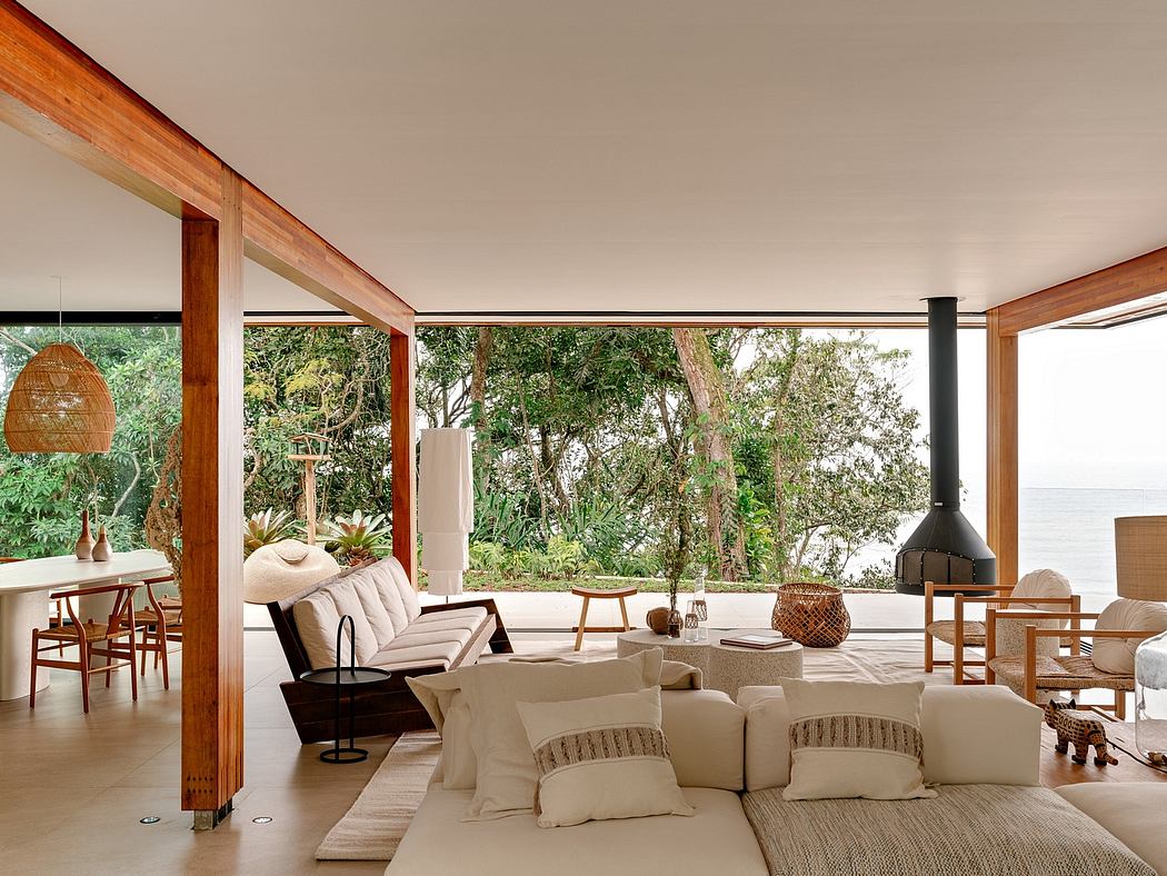 Spacious open-concept living space with wooden beams, large windows, and lush outdoor views.