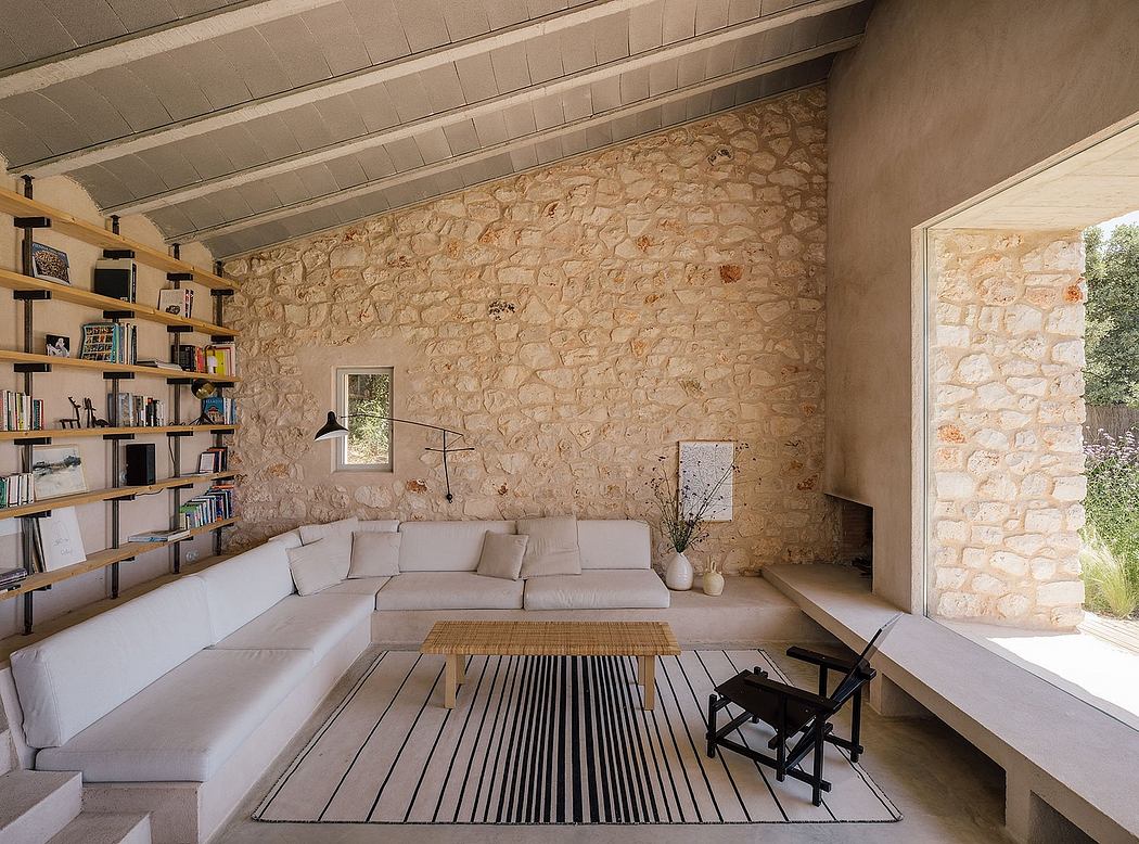 Cozy interior with rustic stone walls, wood-beamed ceiling, and built-in bookshelves.