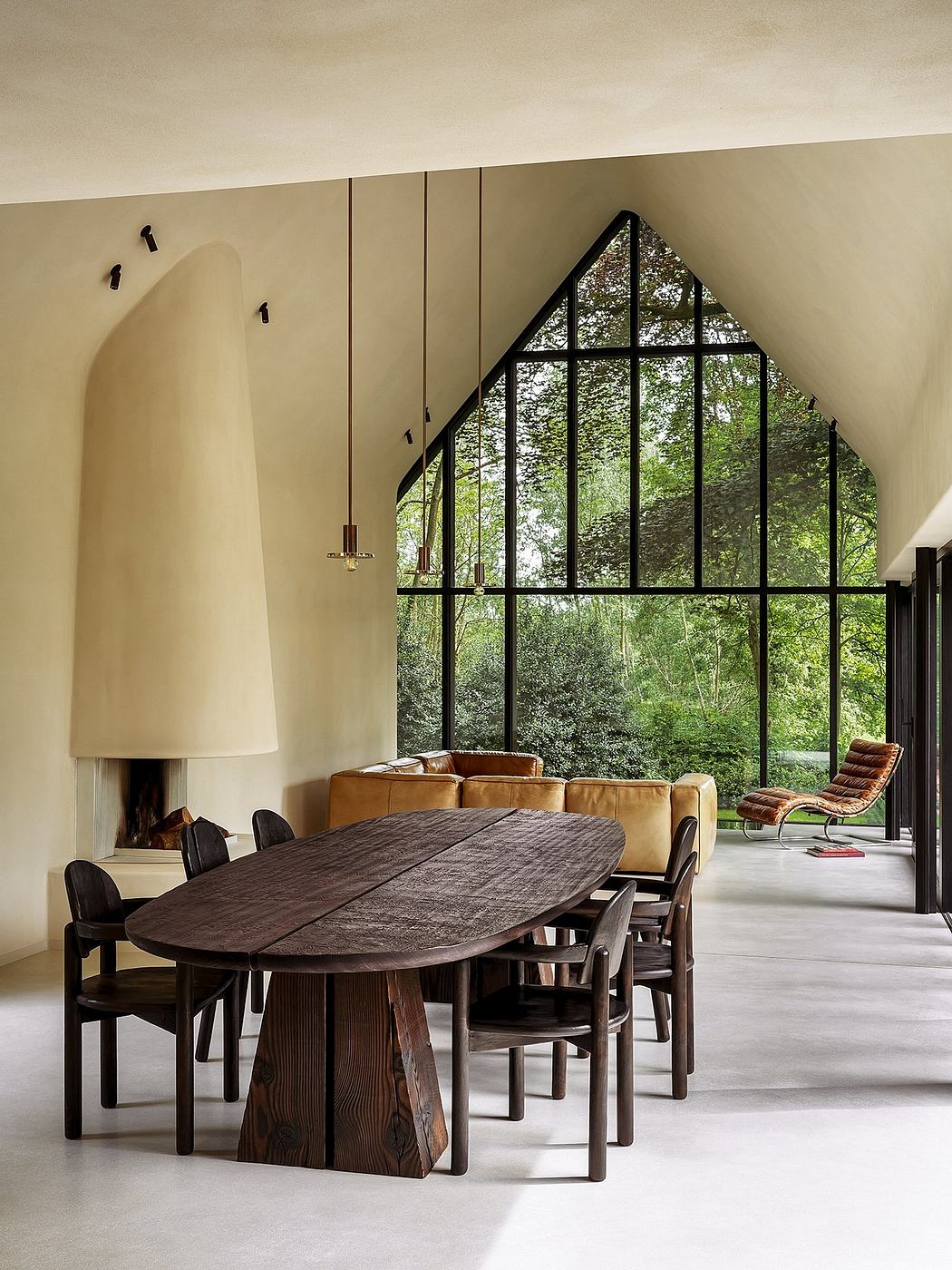 Spacious dining area with large arched window overlooking lush greenery, wooden table and chairs.