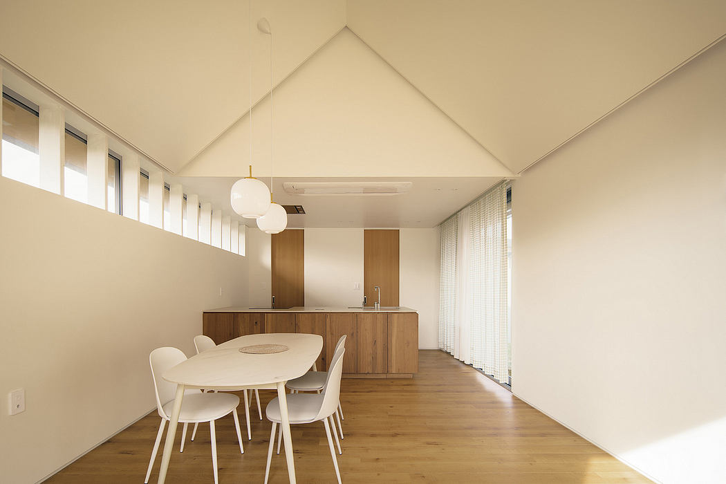 A spacious modern interior featuring a high-vaulted ceiling, wooden furniture, and minimalist lighting.
