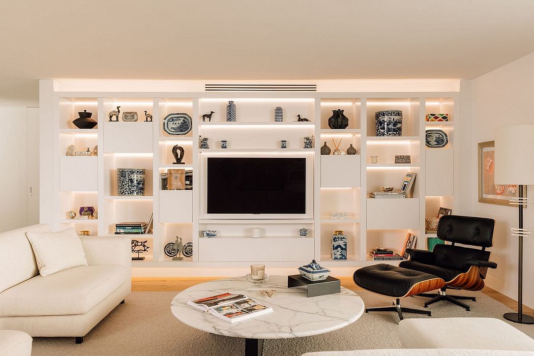 A modern living room featuring a built-in wall unit with shelves, a TV, and decorative accents.