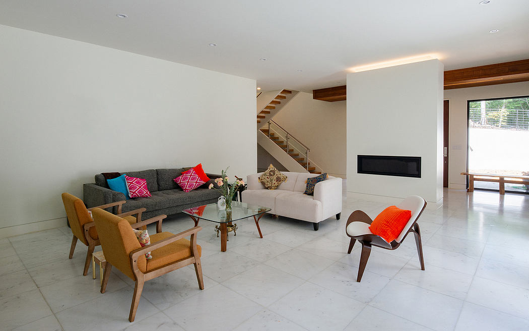 Spacious living room with modern furniture, wood accents, and a glass-topped coffee table.