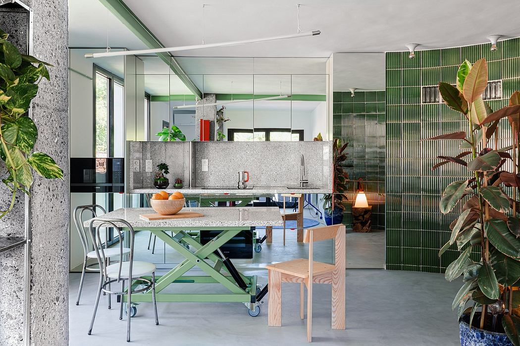 Modern open-concept kitchen and dining area with green accents, concrete surfaces, and natural light.
