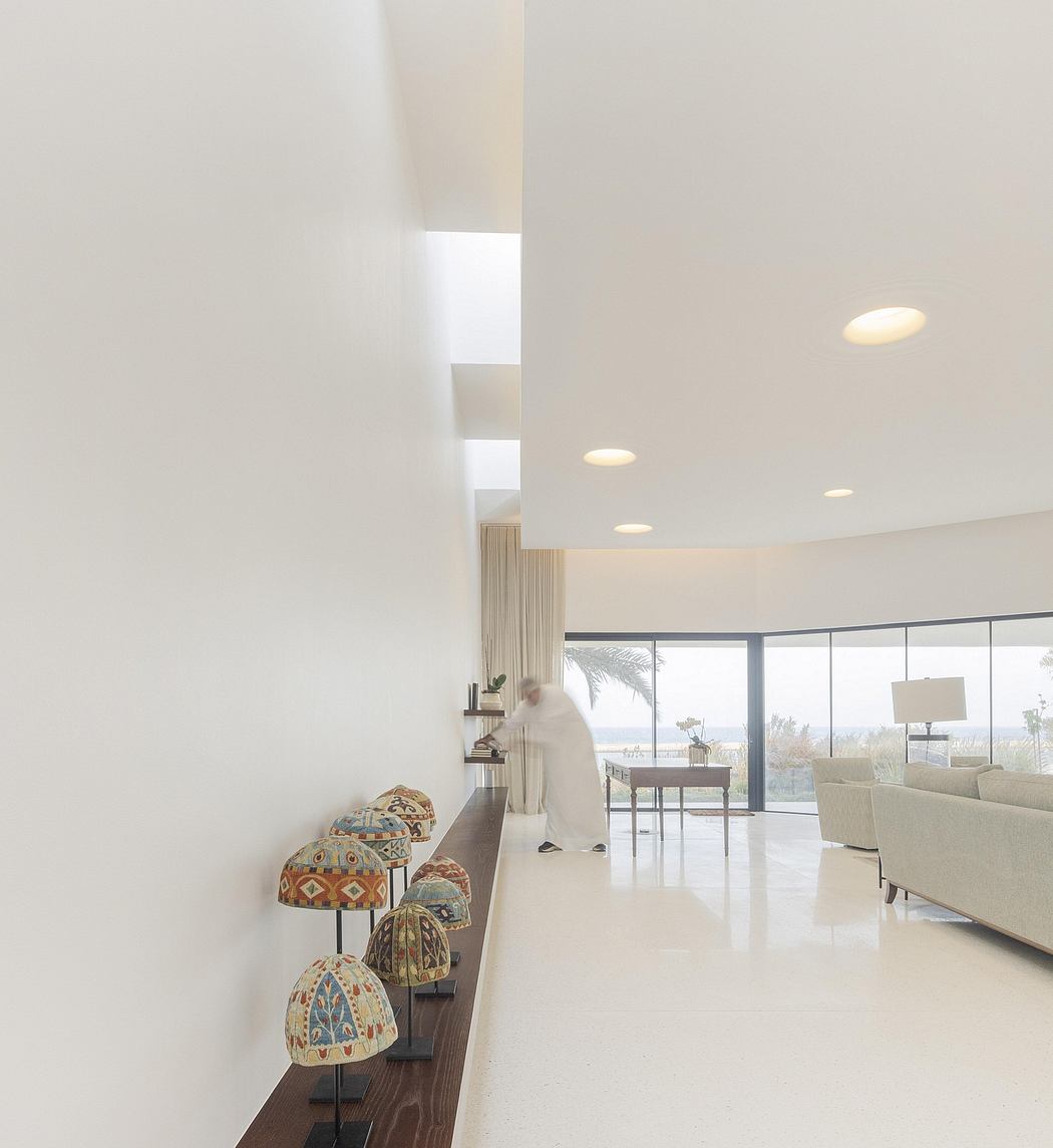 Minimalist living room with vibrant patterned glass sculptures adorning a wooden console.