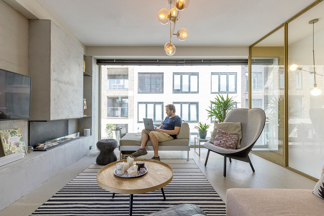 Stylish modern living room with pendant lighting, striped rug, and comfortable furnishings.